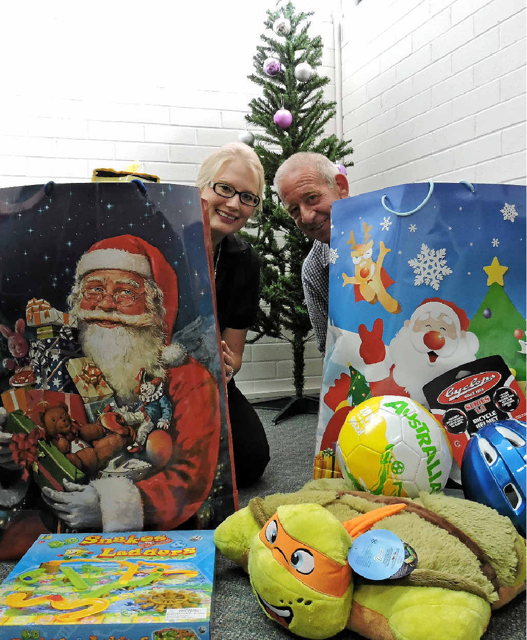 GIVING: Warwick Daily News staff members Simone Nolan and Peter Schmidt help Santa give to needy families.